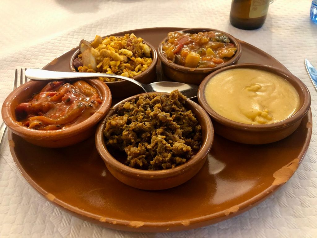 Varios platos típicos de la gastronomía toledana como pisto manchego, migas del pastor y gachas.
